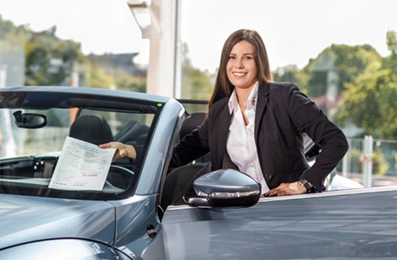 Mitarbeiter legt Dokumente unter die Windschutzscheibe
