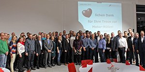 Mitarbeiter stehen auf der Bühne bei Jubiläumsfeier von Motor‑Nützel